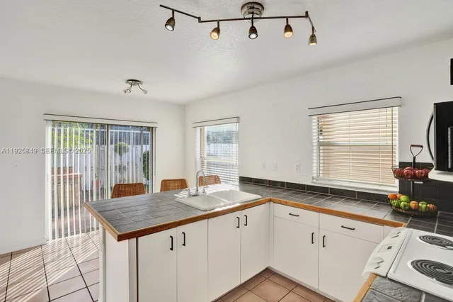 a kitchen with granite countertop stainless steel appliances a sink and cabinets