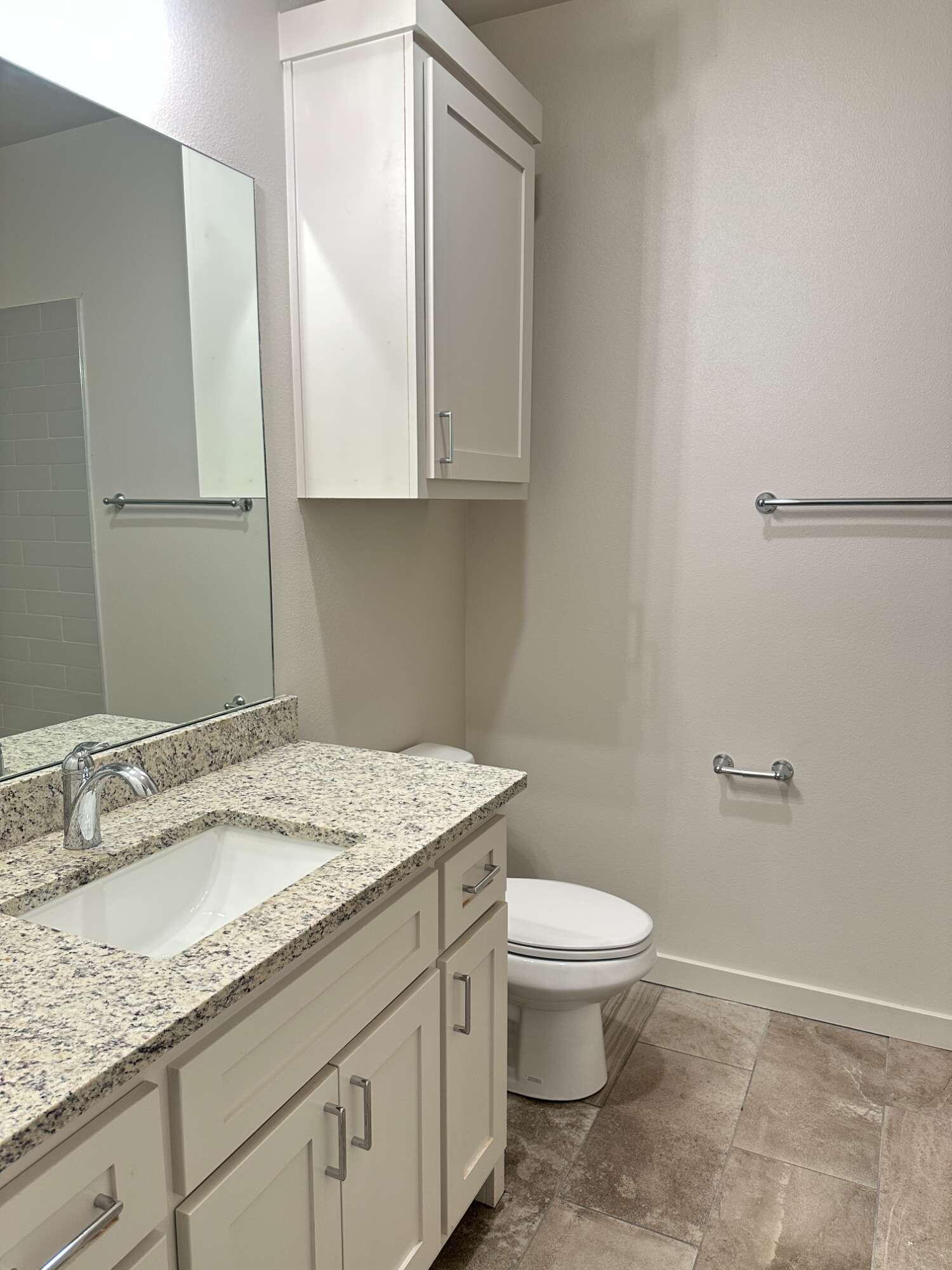 1113 North 7th Street Wolfforth, TX 79382 - Photo 15 of 17 a bathroom with a granite countertop sink a toilet and a mirror