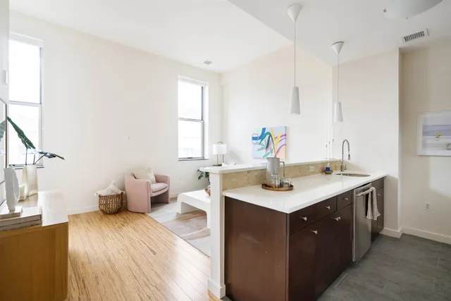 a kitchen with a sink and wooden floor