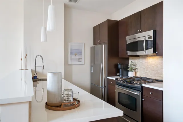 a kitchen with stainless steel appliances kitchen island a refrigerator and a stove top oven