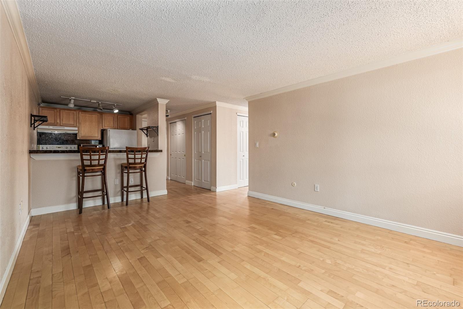 1125 North Washington Street, Unit 207 Denver, CO 80203 - Photo 12 of 33 a view of kitchen with stainless steel appliances wooden floor and chair