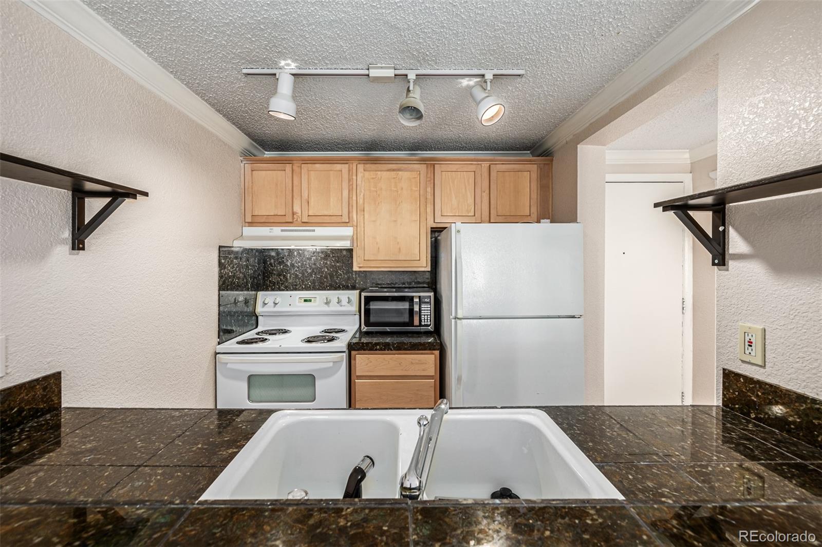 1125 North Washington Street, Unit 207 Denver, CO 80203 - Photo 20 of 33 a kitchen with kitchen island a counter top space appliances and cabinets