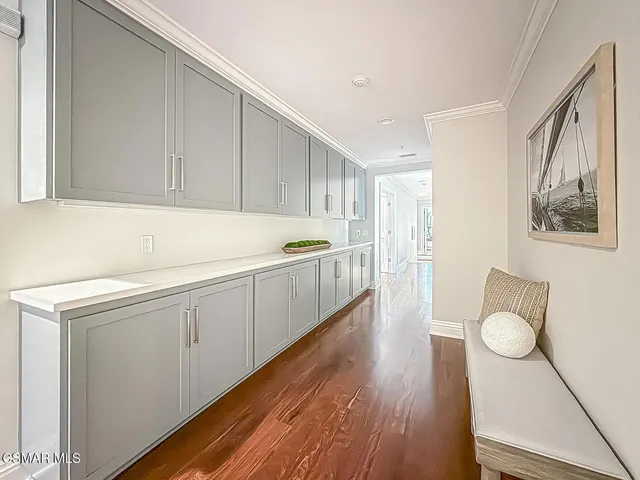 a view of a hallway with wooden floor and chandelier