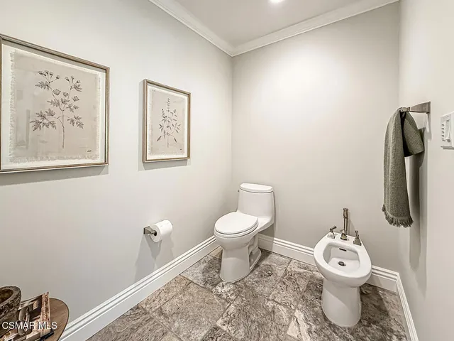 a large white kitchen with granite countertop a large window sink and cabinets