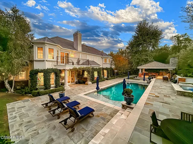 a front view of a house with a yard and trees