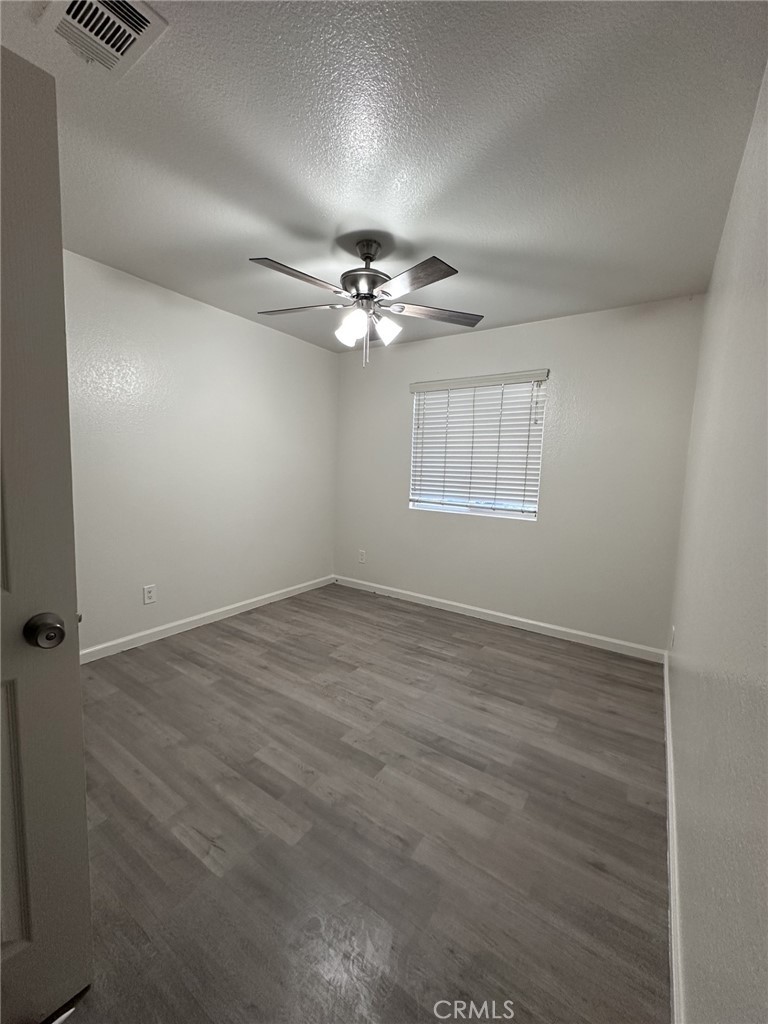 11807 Lupin Road Adelanto, CA 92301 - Photo 7 of 8 an empty room with windows and fan