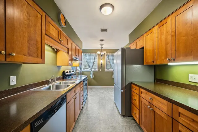 a kitchen with stainless steel appliances a sink stove and cabinets