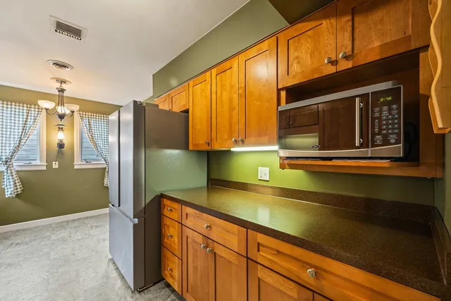 a kitchen with stainless steel appliances granite countertop a refrigerator and a sink