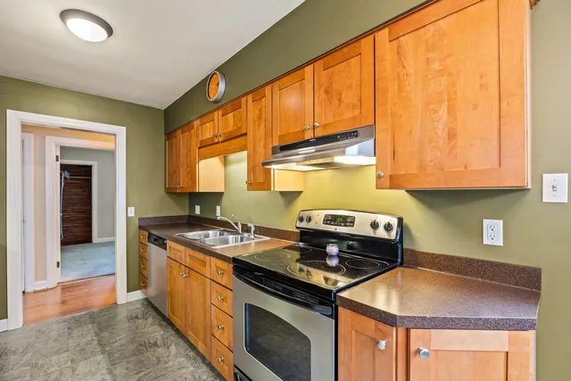 a kitchen with stainless steel appliances granite countertop a stove a sink and a microwave
