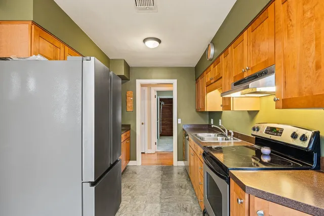 a kitchen with stainless steel appliances granite countertop a refrigerator and a stove