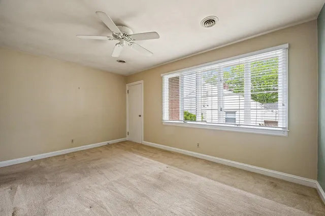 a view of a livingroom with a ceiling fan and window