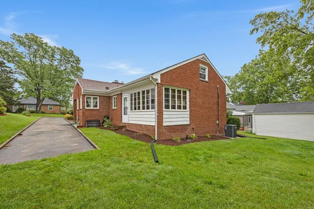 a brick house with a small yard and plants