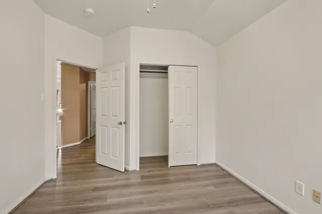 an empty room with wooden floor and window