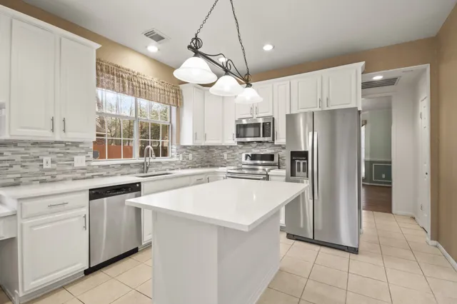 a kitchen with a white center island and cabinets