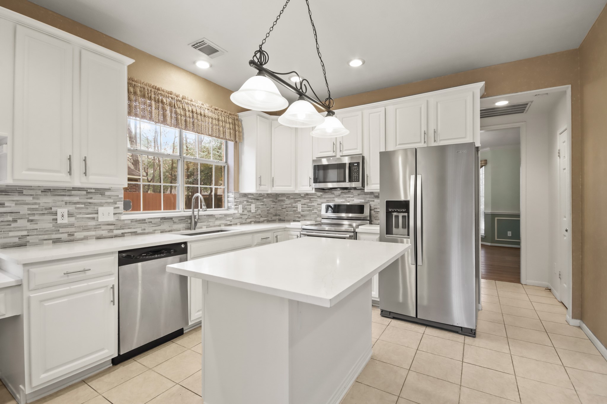 111 South Dreamweaver Circle Spring, TX 77380 - Photo 6 of 30 a kitchen with a white center island and cabinets