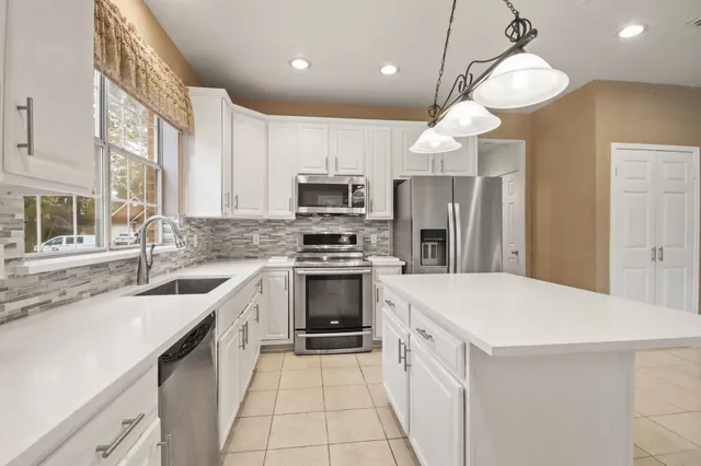 a kitchen with a sink a stove a microwave and a refrigerator