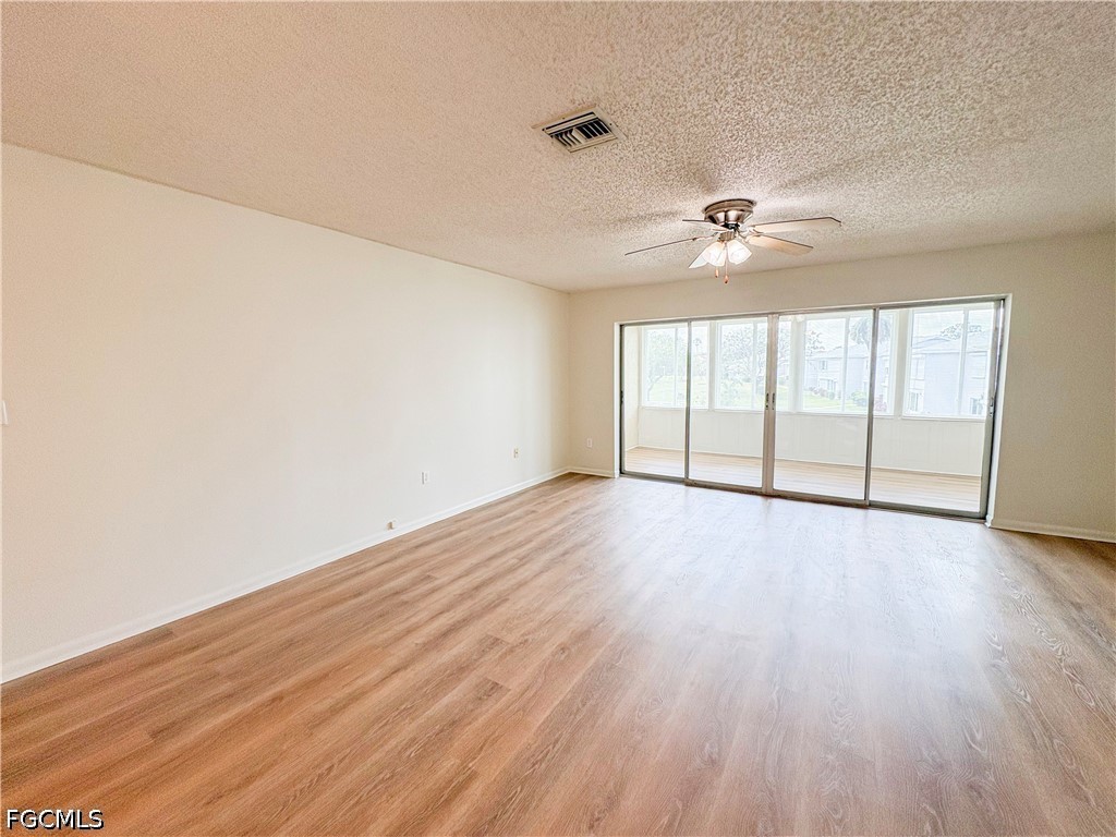 1830 Brantley Road, Unit I7 Fort Myers, FL 33907 - Photo 12 of 34 an empty room with wooden floor fan and windows