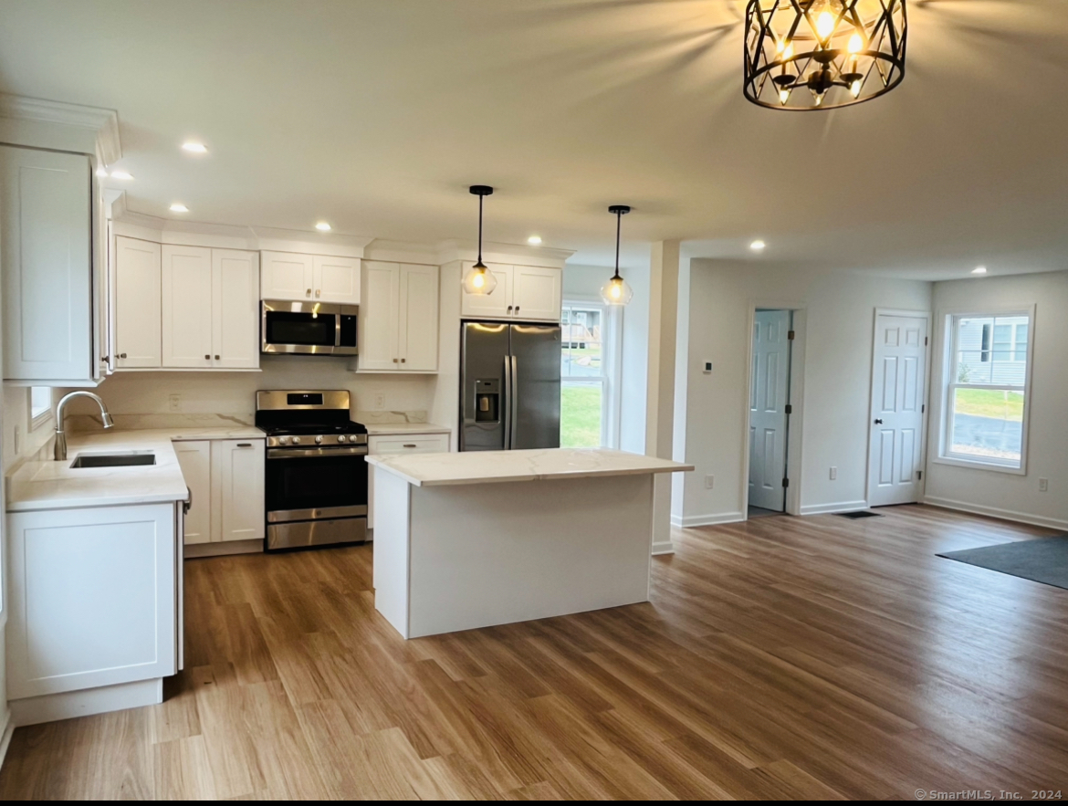 14 Infield Street Bridgeport, CT 06606 - Photo 2 of 8 a kitchen with stainless steel appliances a stove top oven a sink cabinets and a wooden floor
