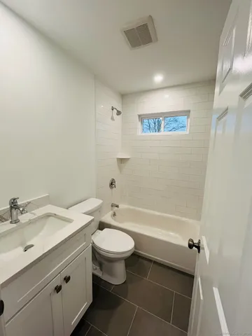 a bathroom with a sink toilet vanity and bathtub
