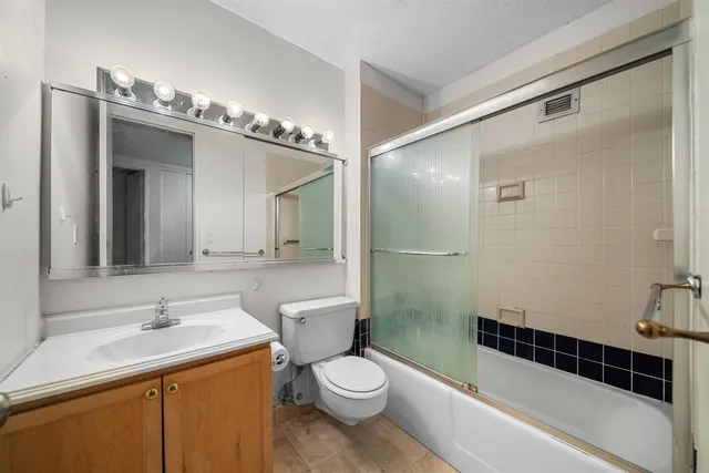 a bathroom with a sink a toilet a mirror and shower