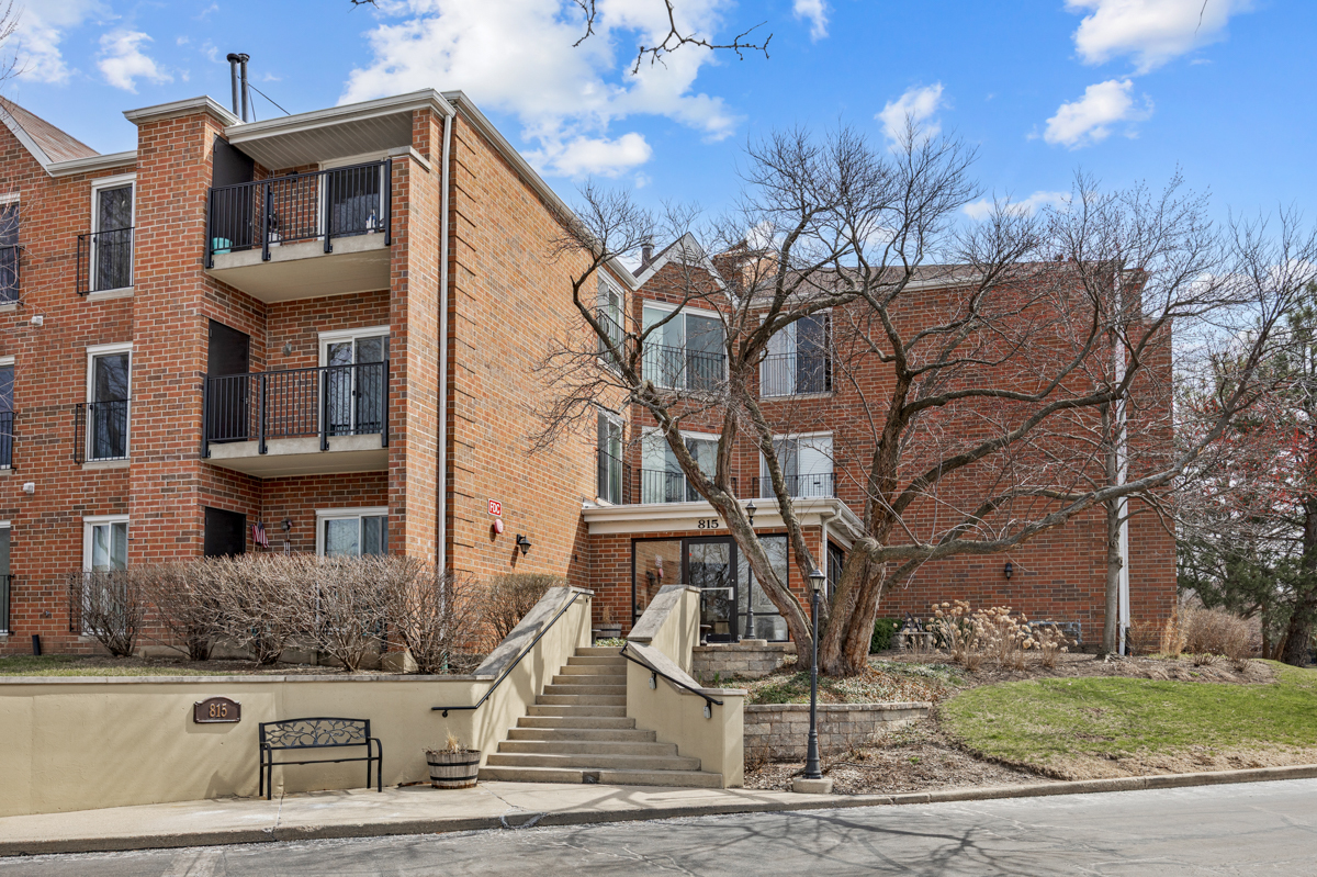 815 Leicester Road, Unit 114A Elk Grove Village, IL 60007 - Photo 1 of 20 a front view of a house with garden