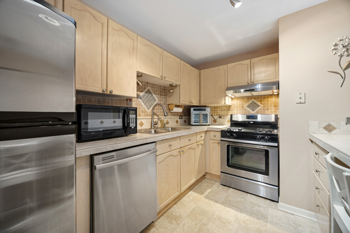 815 Leicester Road, Unit 114A Elk Grove Village, IL 60007 - Photo 11 of 20 a kitchen with granite countertop cabinets stainless steel appliances and a counter space