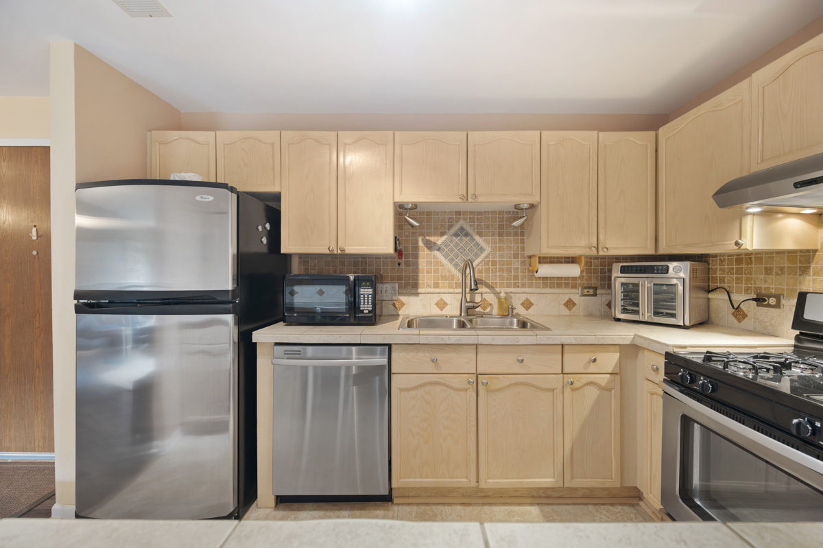 815 Leicester Road, Unit 114A Elk Grove Village, IL 60007 - Photo 12 of 20 a kitchen with stainless steel appliances granite countertop a refrigerator sink and stove