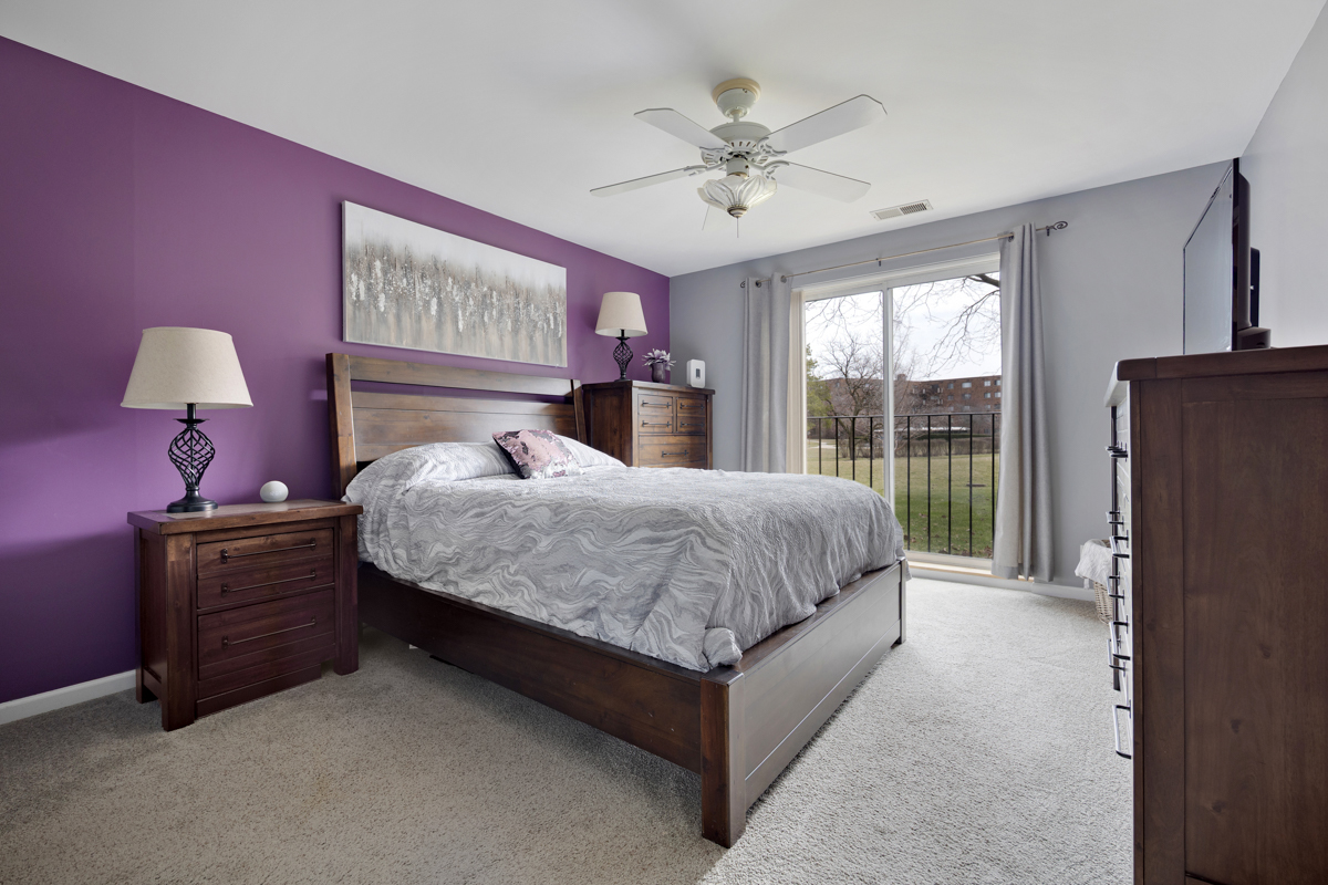 815 Leicester Road, Unit 114A Elk Grove Village, IL 60007 - Photo 14 of 20 a bedroom with a bed dresser and a large window