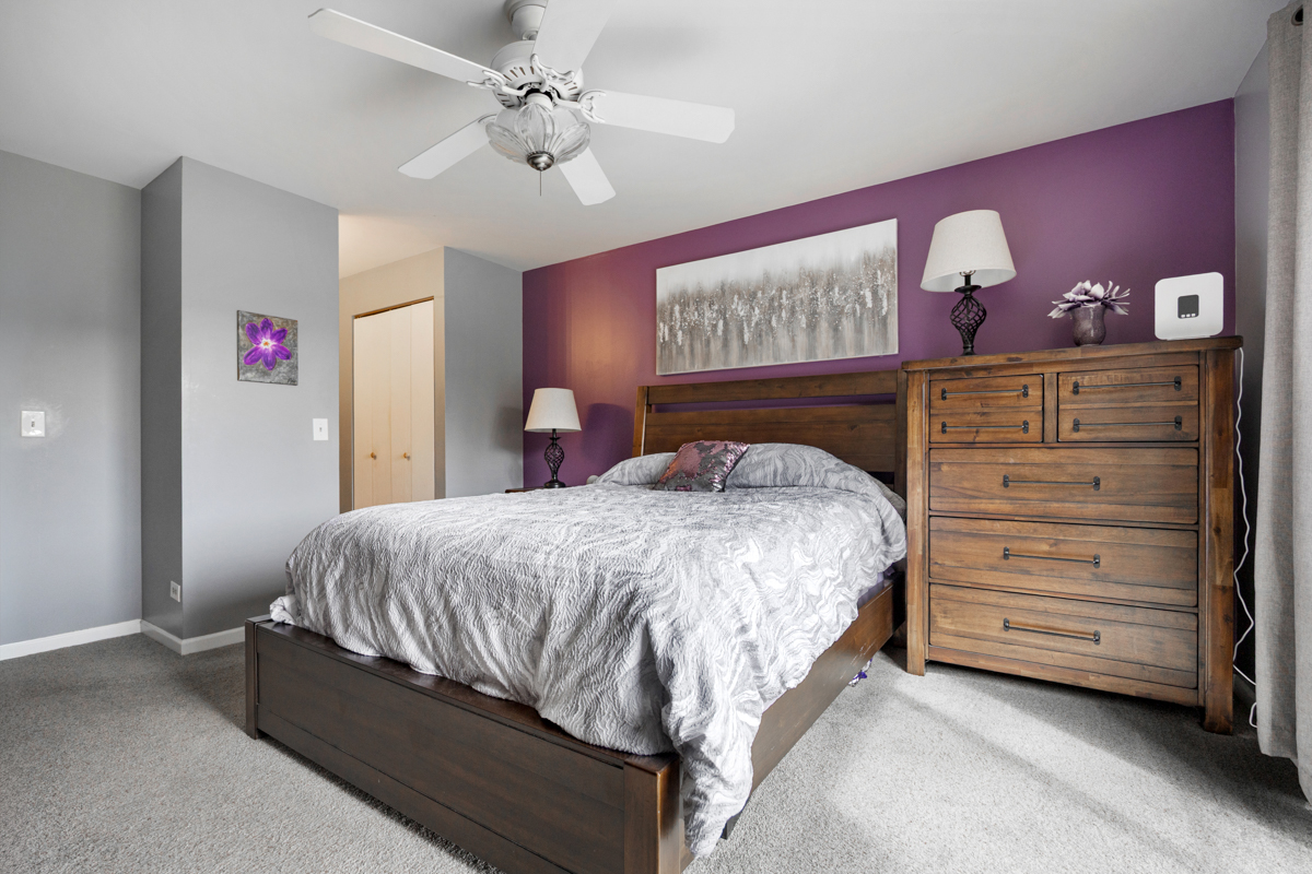 815 Leicester Road, Unit 114A Elk Grove Village, IL 60007 - Photo 15 of 20 a bed sitting in a bedroom chandelier and dresser
