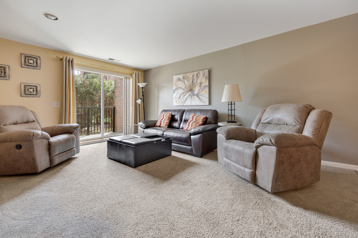 815 Leicester Road, Unit 114A Elk Grove Village, IL 60007 - Photo 4 of 20 a living room with furniture and a large window