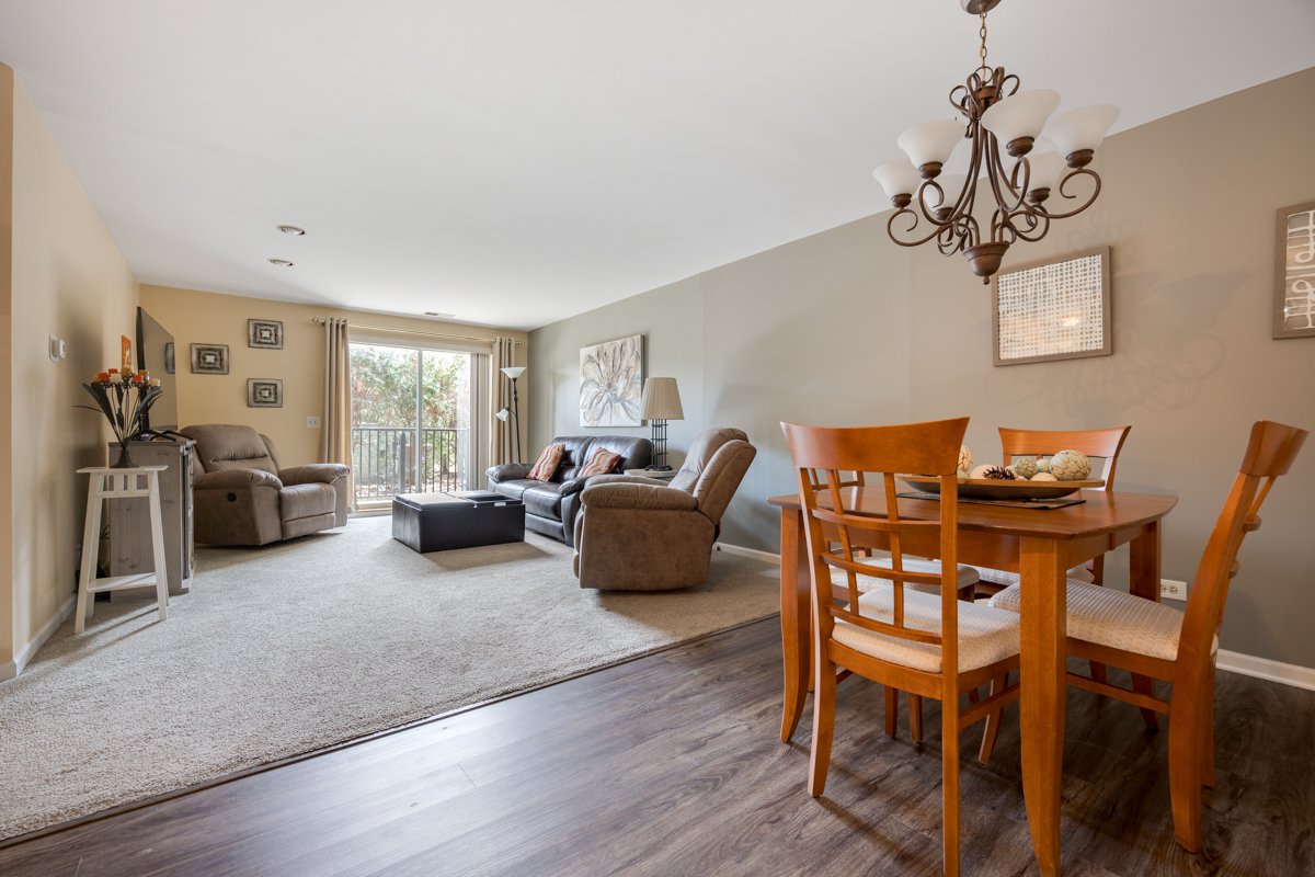 815 Leicester Road, Unit 114A Elk Grove Village, IL 60007 - Photo 6 of 20 a living room with furniture and a chandelier