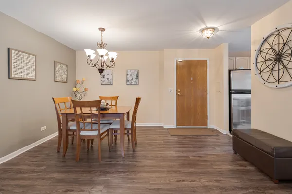 a dining room with furniture a chandelier and wooden floor