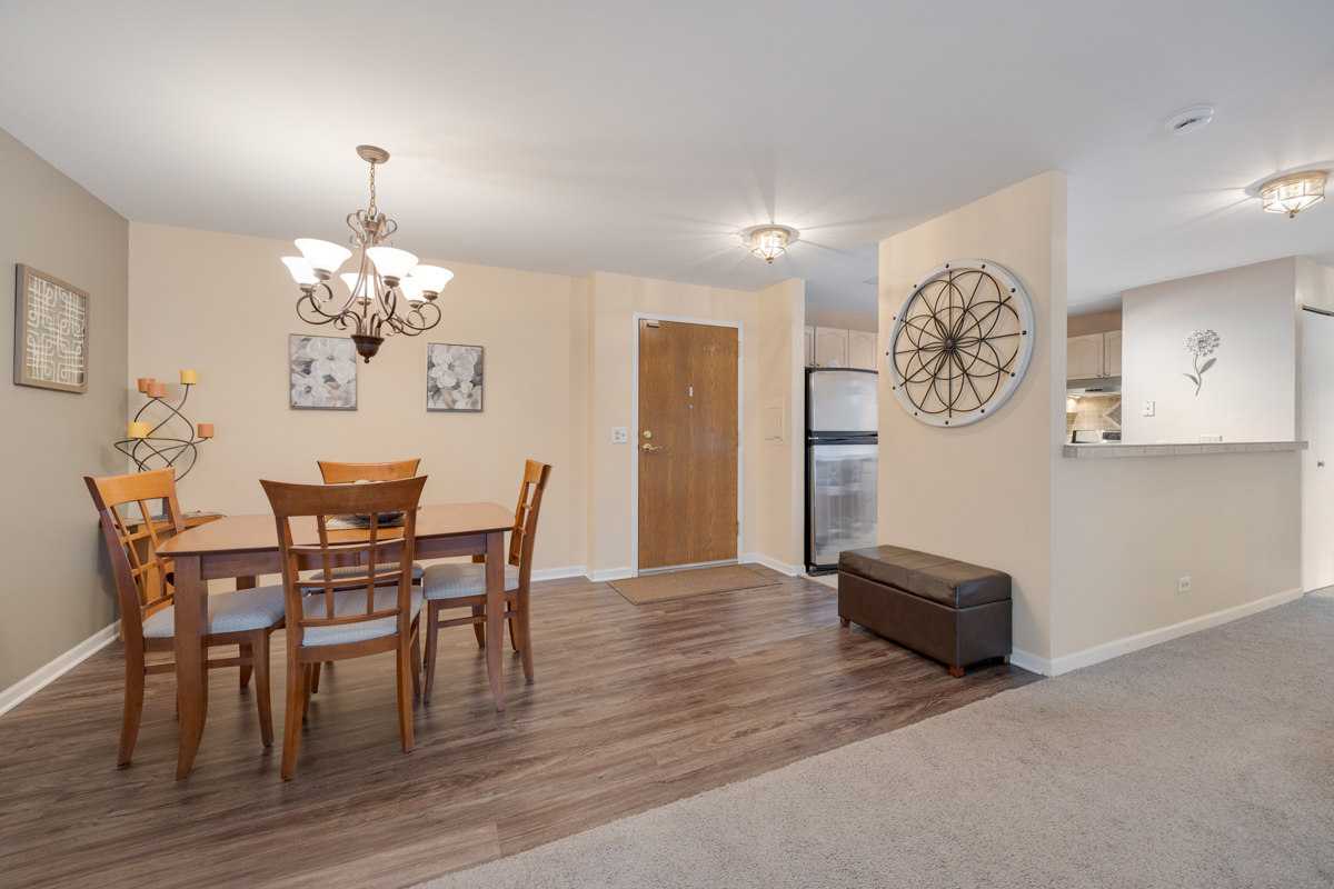 815 Leicester Road, Unit 114A Elk Grove Village, IL 60007 - Photo 8 of 20 a view of a dining room with furniture and wooden floor