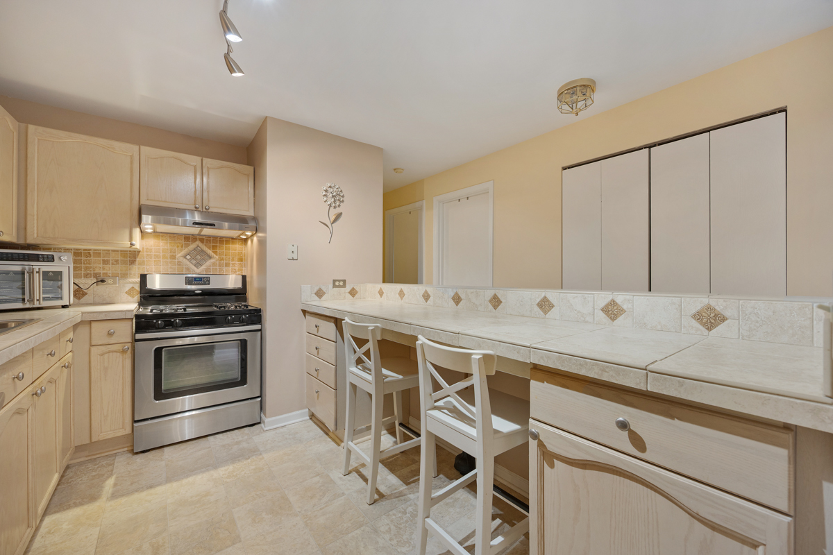 815 Leicester Road, Unit 114A Elk Grove Village, IL 60007 - Photo 10 of 20 a kitchen with a sink stove and cabinets
