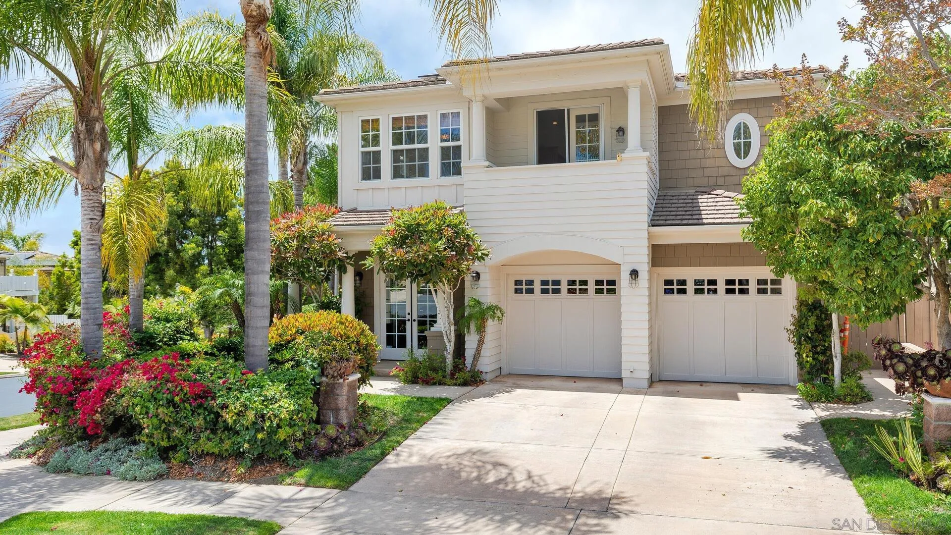 a view of a house with a yard and potted plants