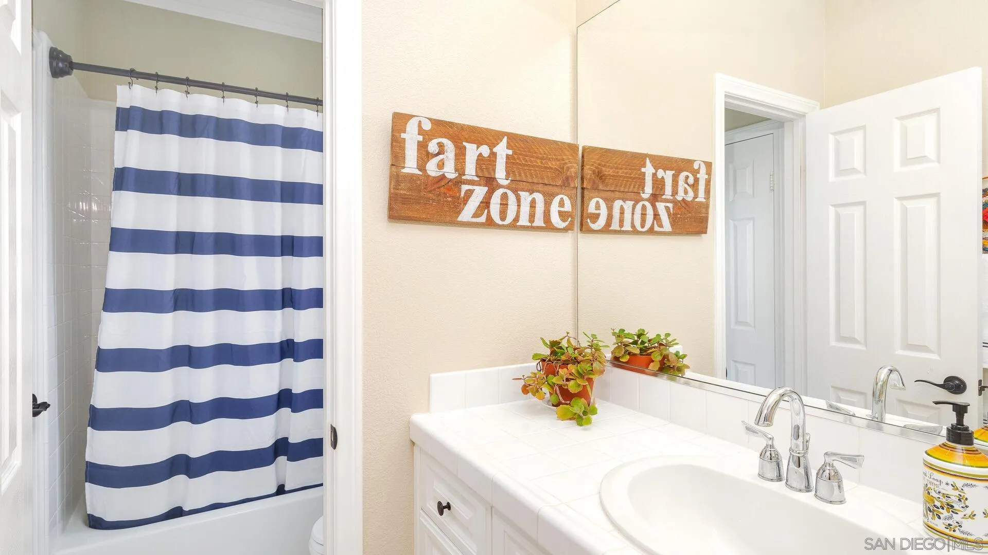694 Rihely Place Encinitas, CA 92024 - Photo 20 of 31 a bathroom with a sink a mirror a vanity and a shower