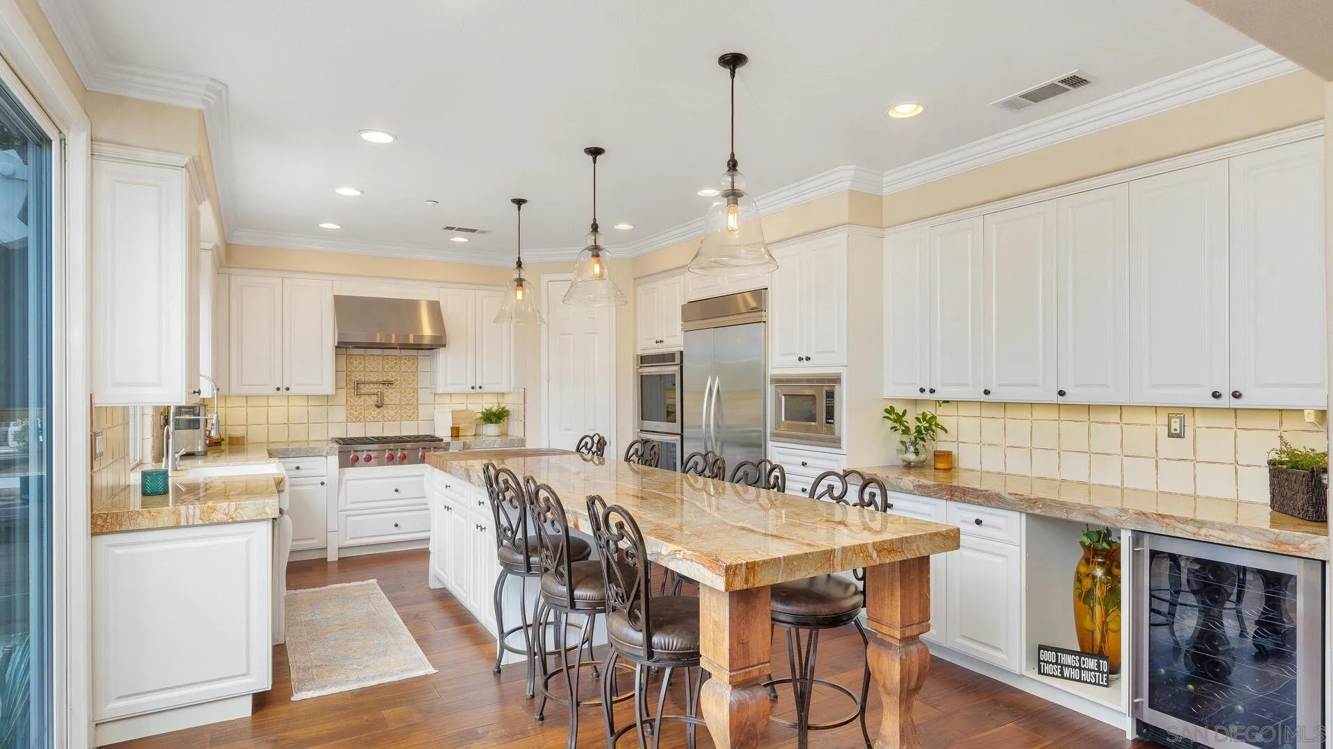694 Rihely Place Encinitas, CA 92024 - Photo 7 of 31 a kitchen with stainless steel appliances kitchen island granite countertop a table chairs sink and cabinets