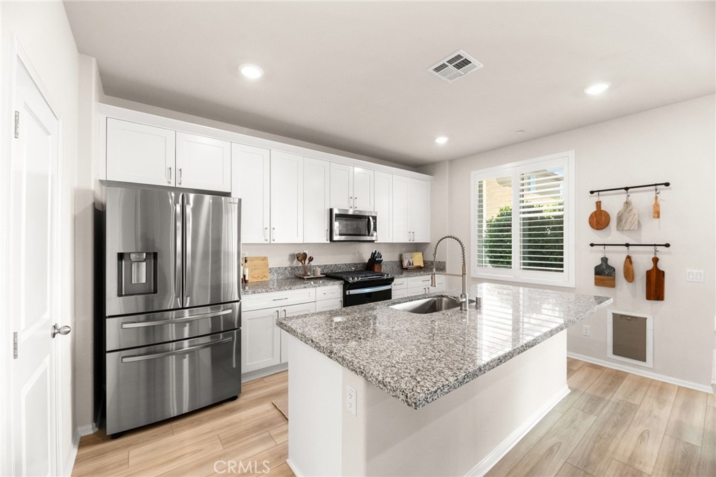 36362 Arcs Street Winchester, CA 92596 - Photo 14 of 54 a kitchen with granite countertop stainless steel appliances a refrigerator sink and microwave