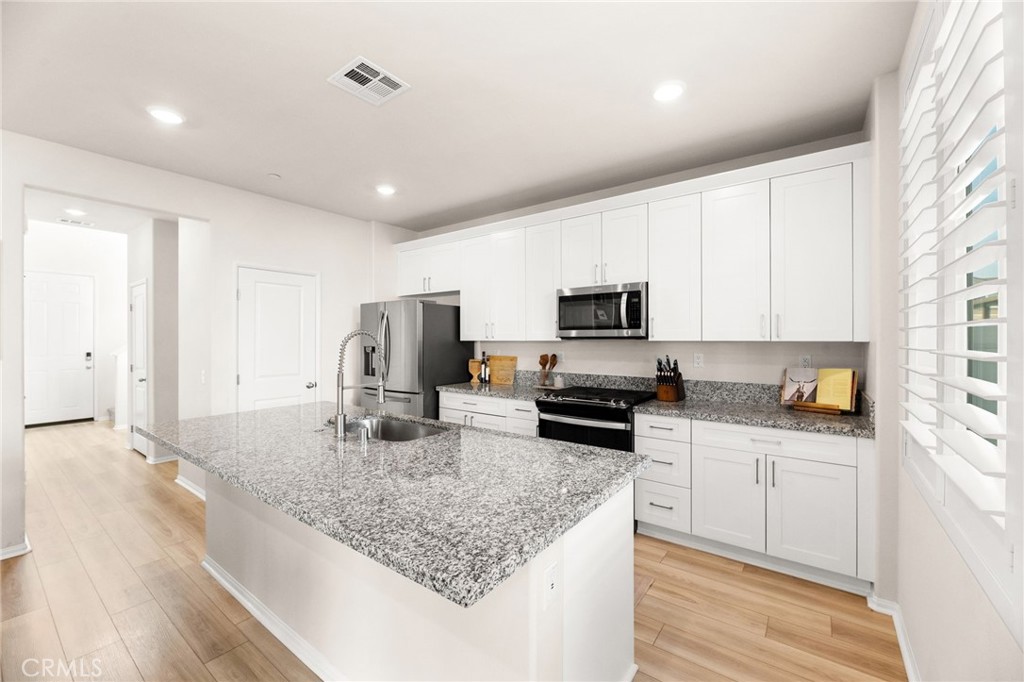 36362 Arcs Street Winchester, CA 92596 - Photo 15 of 54 a kitchen with stainless steel appliances granite countertop a sink refrigerator and microwave