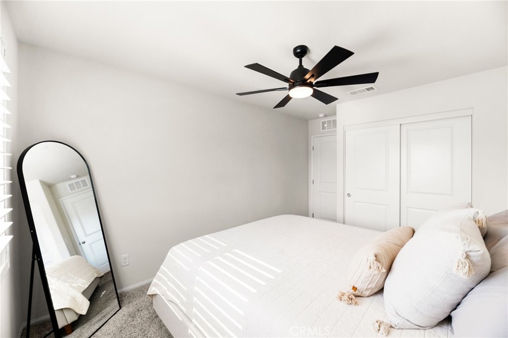 36362 Arcs Street Winchester, CA 92596 - Photo 32 of 54 a bedroom with a bed and a large mirror