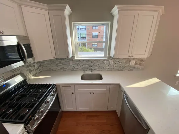 a kitchen with a sink stove and cabinets