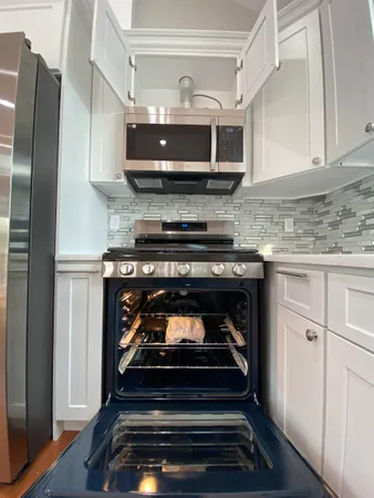 a stove top oven sitting inside of a kitchen