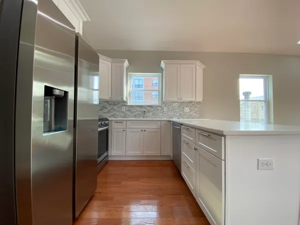 a kitchen with a sink cabinets stainless steel appliances and a window