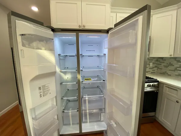 a kitchen with stainless steel appliances granite countertop a refrigerator a stove and a sink