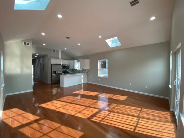 a large white kitchen with kitchen island granite countertop a large counter top