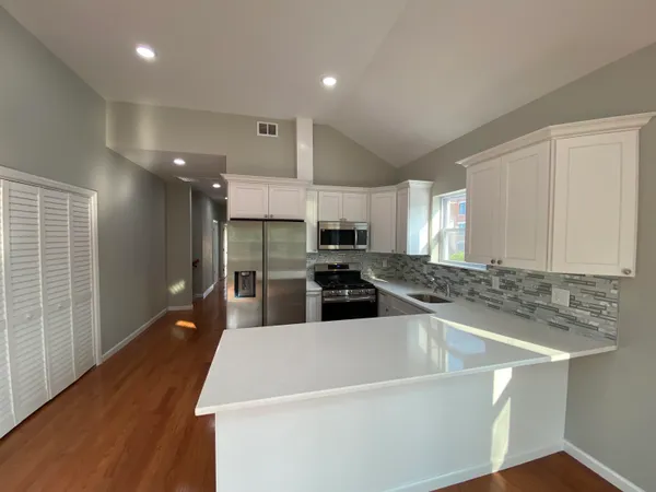 a bedroom with a bed and a view of kitchen