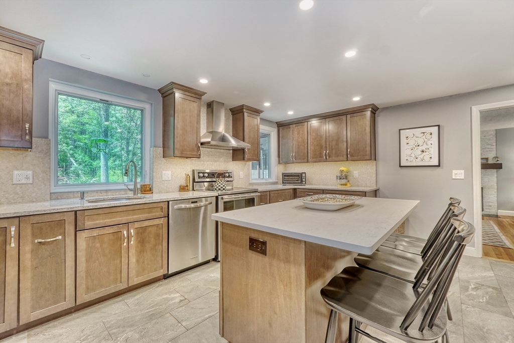 162 Border Road Concord, MA 01742 - Photo 12 of 39 a kitchen with a stove a sink a dining table and chairs