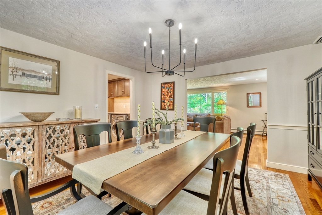 162 Border Road Concord, MA 01742 - Photo 17 of 39 a dining room with furniture a chandelier and wooden floor