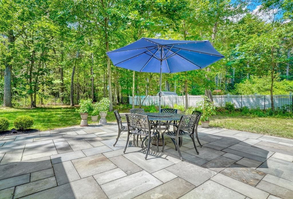 162 Border Road Concord, MA 01742 - Photo 33 of 39 a view of a patio with table and chairs under an umbrella