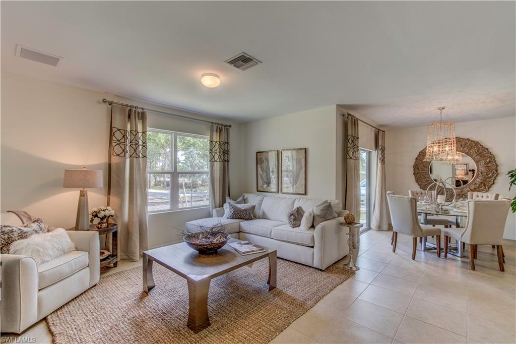 679 Hadley Place East Naples, FL 34104 - Photo 3 of 9 a living room with furniture a table and a large window
